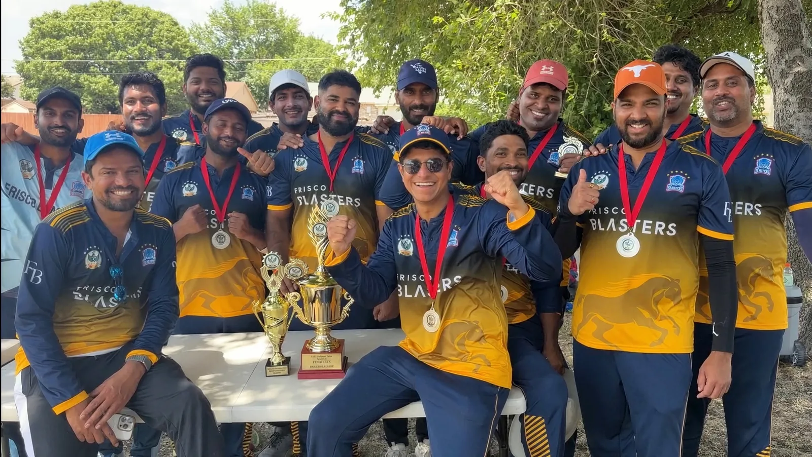 Team celebration in navy and gold custom cricket jerseys