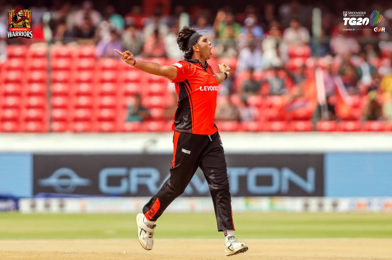 Cricket player celebrating in orange and black kit