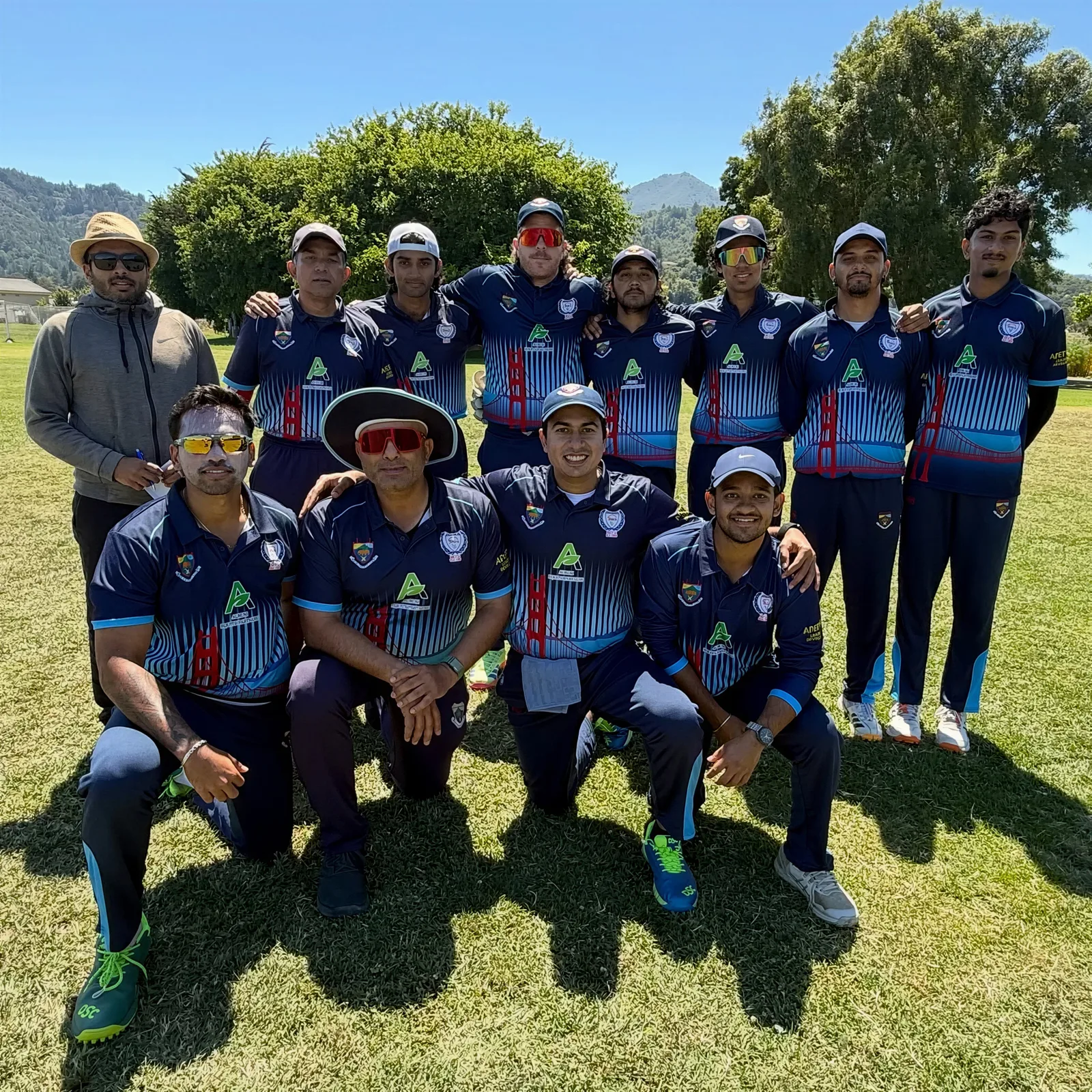 Cricket team group posing in navy custom cricket jerseys